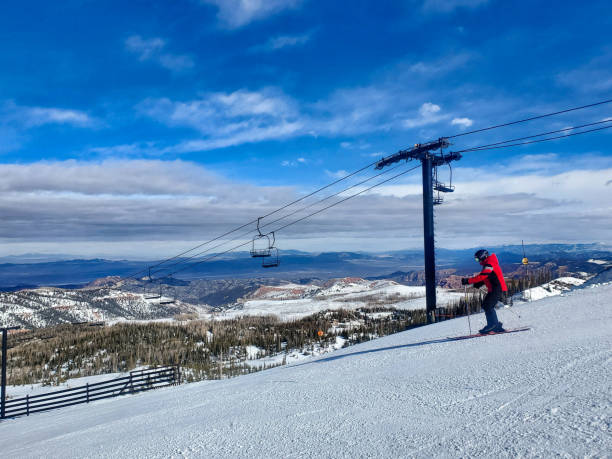 Brian Head, Utah, USA- February 19, 2024: Lone skier under a lift, Brian Head ski resort, Utah.