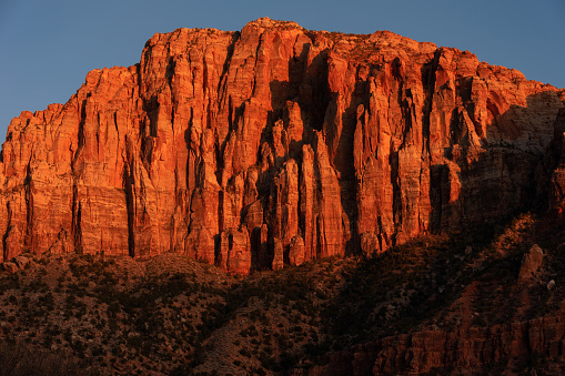 The mountains inside the Zion National Park is lit up by the light from the sunset. Seen at sunset in Utah, United States.
