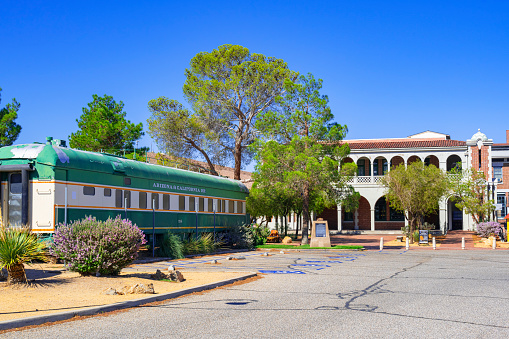 Barstow, California, United States - August 31, 2023:  Old train wagon of the Arizona & California Railroad and the railroad station of Barstow in the background.
