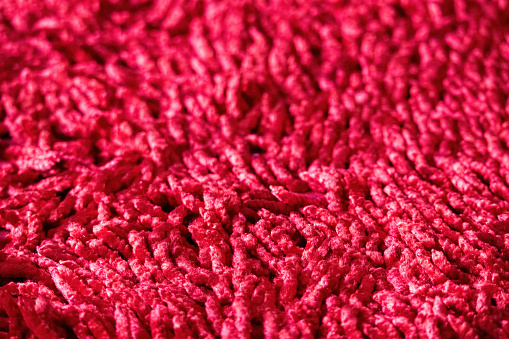 Red carpet texture background. Bright red fancy cotton carpet close-up photo.