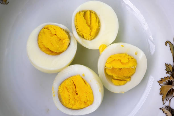Two hard-boiled eggs are cut into four pieces on a plate. Nutrition concept.