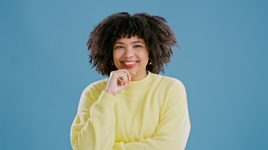 Portrait of happy woman, confident or trendy fashion on blue background for cool style, smile or jersey. Studio, female person or proud biracial model in cool clothes for winter style or mockup space
