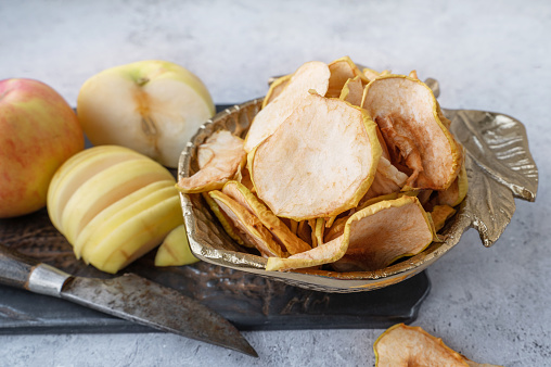 Dried apple chips in a bowl. Dehydrated apples. Homemade dried organic apple slices.