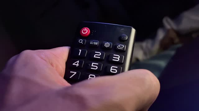 Pressing the power button on a television remote control