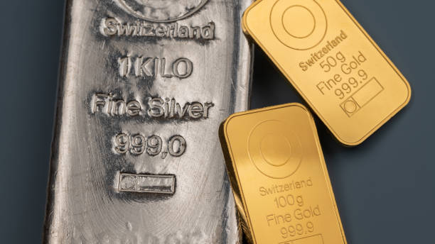 istock Two minted gold bars and silver cast bar on a blue 2043033273