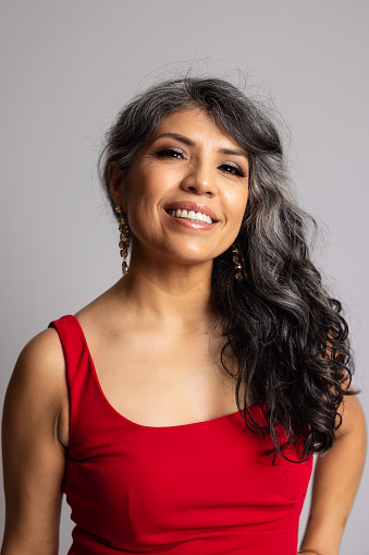 A beautiful portrait of a Hispanic woman on a grey backdrop.