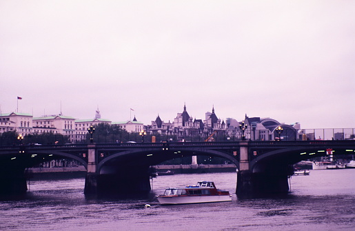 Looking toward the Westminster Bridge, the royal horseguards hotel and Charing Cross Station along the River Thames in London during early 1990s