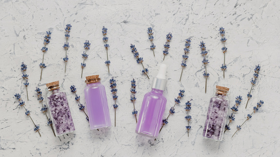 Natural cosmetic concept, seasalt in bottles with lavender flowers top view. Organic skincare products and spa, neutral aesthetic