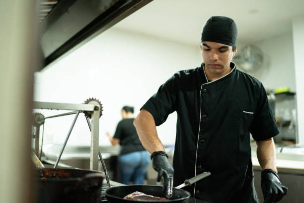 istock Young chef man frying a meat on kitchen at restaurant 2043093235