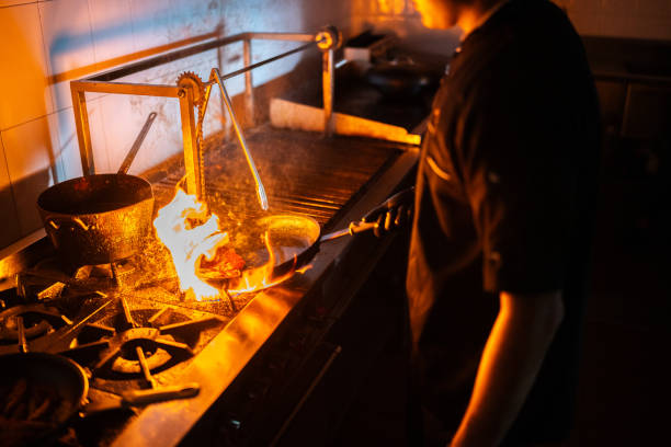 istock Young chef man flambe a food at restaurant kitchen 2043093778