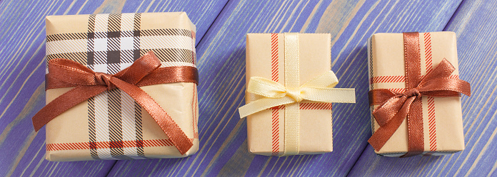 Wrapped colorful gifts with ribbons for Christmas, Valentine, birthday or other celebration lying on old boards