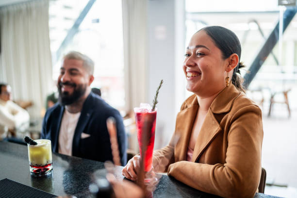 istock Young woman talking with bartender at bar 2043100123