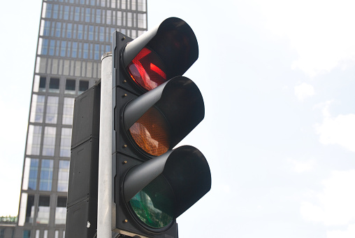 Traffic light with yellow light on, signal for proceed with caution.
