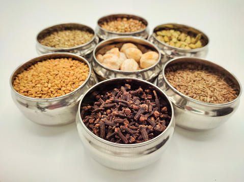 Focus scene on spices - candlenut, cardamom, fennel, clove, cumin, coriander seeds and dhall (dahl)