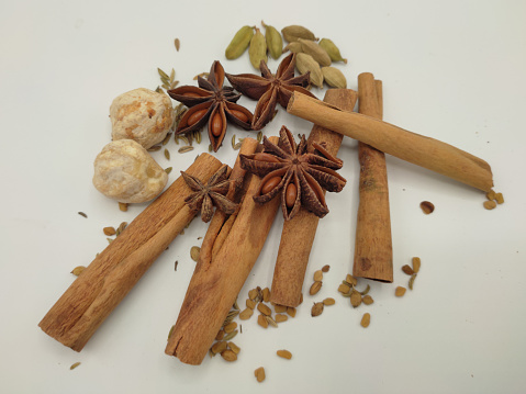 Focus scene on spices - cardamom, star anise, cinnamon stick, candlenut (kukui nut)