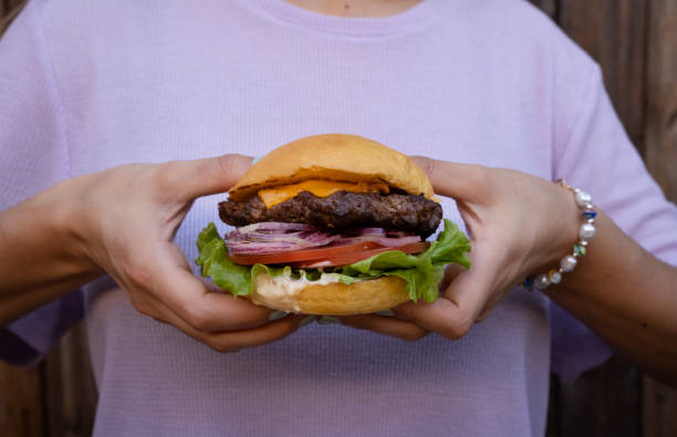 istock Woman holding a delicious burger 2043178568