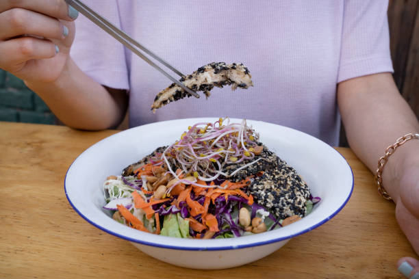 istock A woman having a gourmet asian salad 2043184896