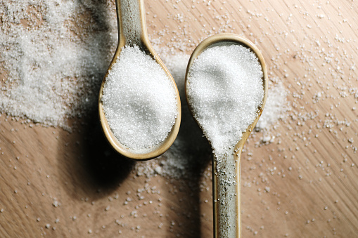 Close-up of white sugar on spoons