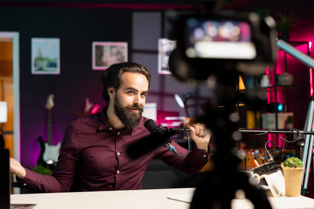 istock Influencer in rgb lit studio preparing microphone for vlog shooting 2043193859