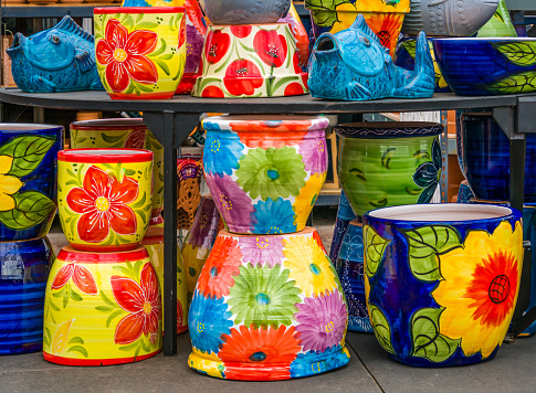 Stacks of brightly painted flower pots in a retail display.