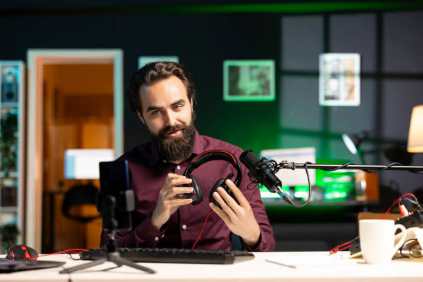 istock Tech expert promoting music listening device in neon lit studio 2043202171