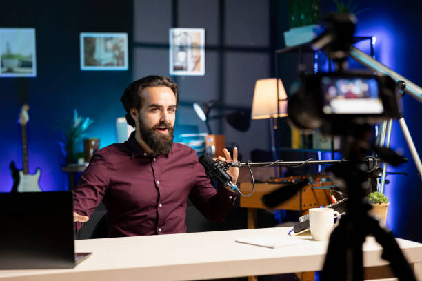 istock Man uses content creation recording mic in apartment 2043204303