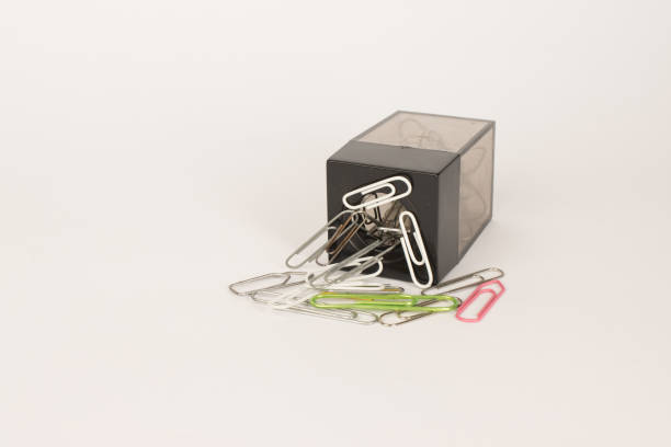 A Magnetic paper clip holder turned on its side with clip all around it.