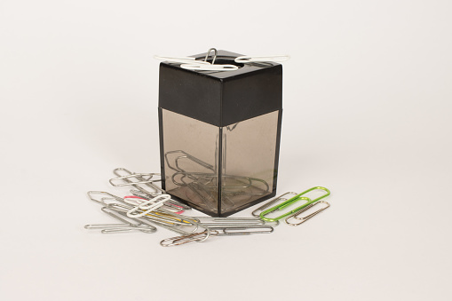 A Magnetic paper clip holder with clips all around it.