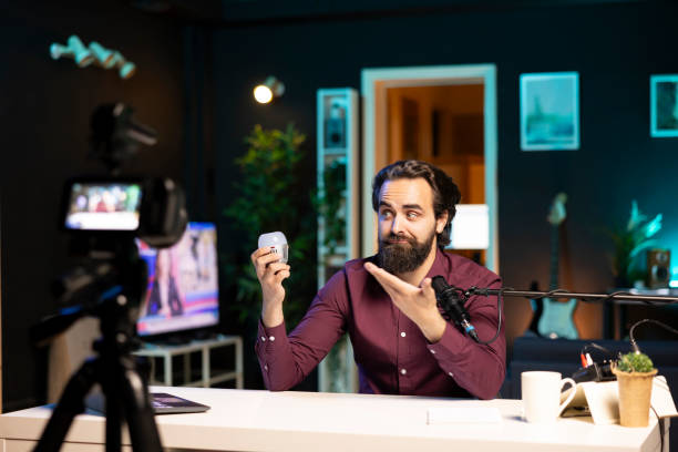 istock Tech expert looking at defective smart light bulb, trying to repair it while filming 2043207442