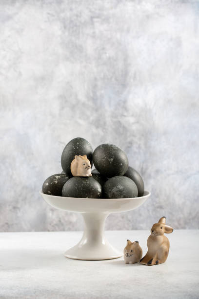 istock Easter composition with colored eggs and Easter bunny. Dyed marbled gray eggs in bowl on gray background. Easter eggs natural dyed with hibiscus tea. Happy Easter. Copy space. 2043213497