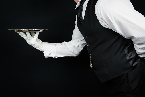 Butler in Black Vest and White Gloves Holding Tray