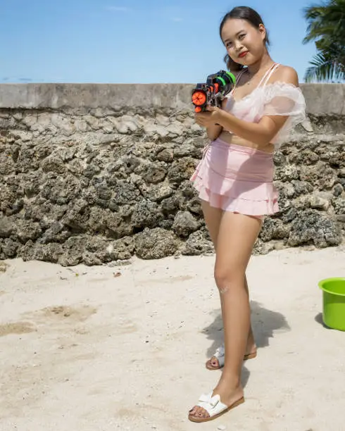 A Philippine girl in a swimsuit with a water gun