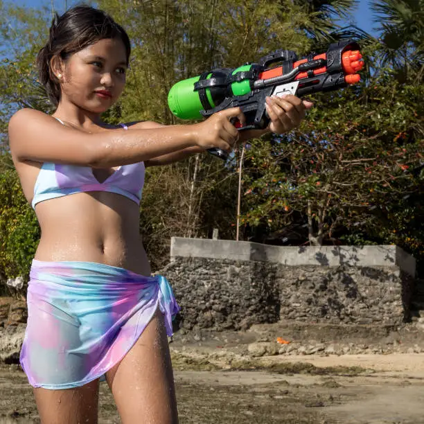 A Philippine girl in a swimsuit with a water gun