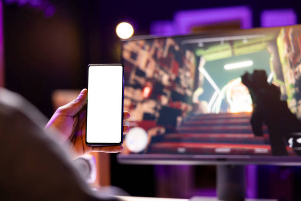 istock Man texting friends on isolated screen phone while playing videogame 2043228321