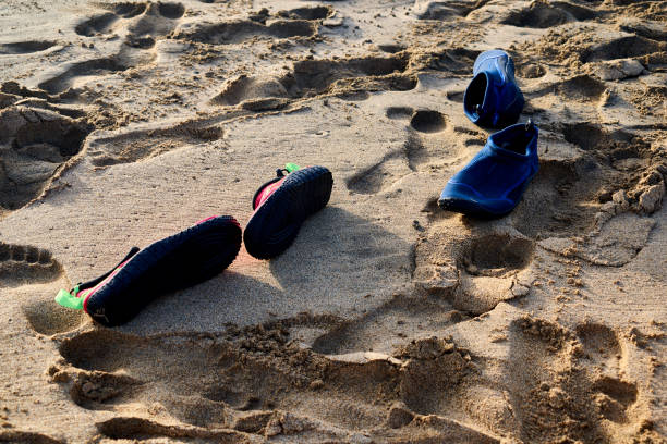 bathing shoes on sand full of footprints