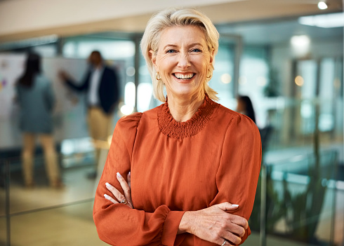Happy woman, portrait and senior with confidence for business, leadership or management at the office. Face of mature female person, boss or CEO with smile and arm crossed of corporate professional