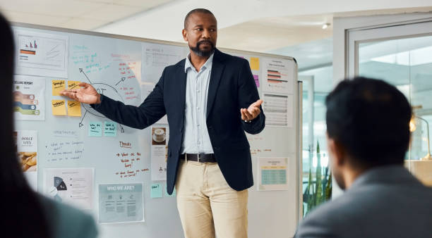 istock Business, african man and board for workshop, training and mentorship with planning or discussion. Presentation, meeting and collaboration for growth, future and investment for company and work goals 2043246352