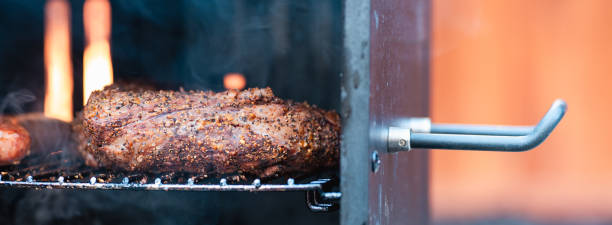 istock a meat dish being cooked on a grill by someone who is smoking 2043253977