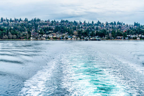 Seattle, WA, USA-July 2022; View of one a Washington State Ferry en route to one of the destinations sailing in the Puget Sound with snow topped mountains of Olympic National Park on horizon