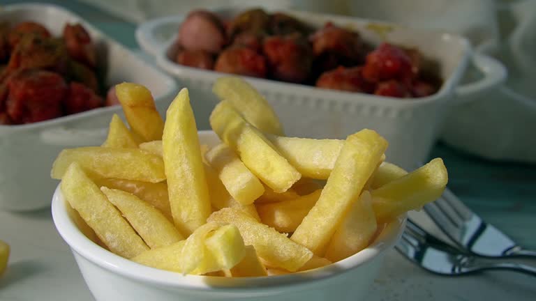 Hand taking a fried potato stick