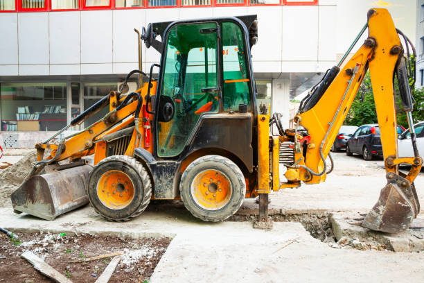 istock A yellow tractor with front and rear hydraulic buckets stands on a construction site in the city. 2043265469