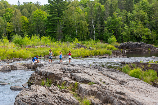 Family exploring the bank of the St. Louis River in northern Minnesota woods. Taken at Jay Cooke State Park.