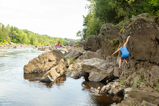 Two girls (sisters) exploring the riverbank of the St. Louis River in Minnesota, USA. Taken at the Jay Cooke State Park on a beautiful summer day.