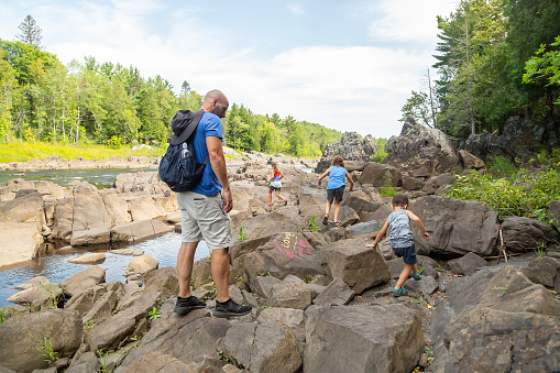 Family exploring the riverbank of the St. Louis River in Minnesota, USA. Taken at the Jay Cooke State Park on a beautiful summer day.