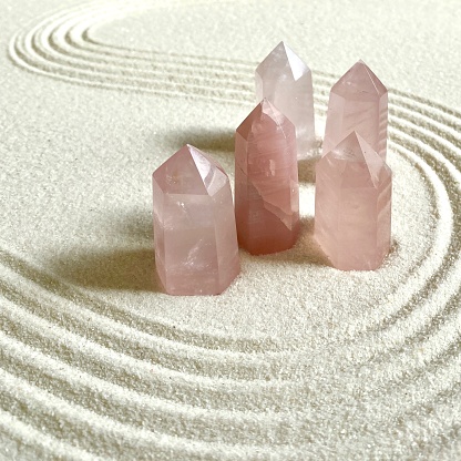 collection of rose quartz towers on sand