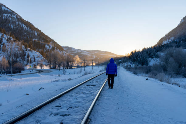 istock Mature man walks along train track in winter 2043332769