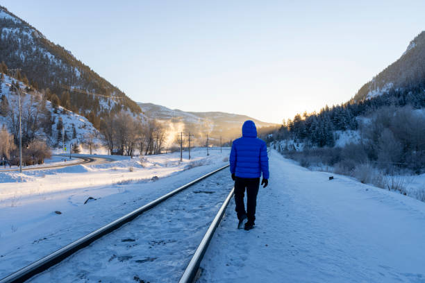 istock Mature man walks along train track in winter 2043332770