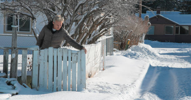 istock Mature man walks through gated fence in winter 2043339689
