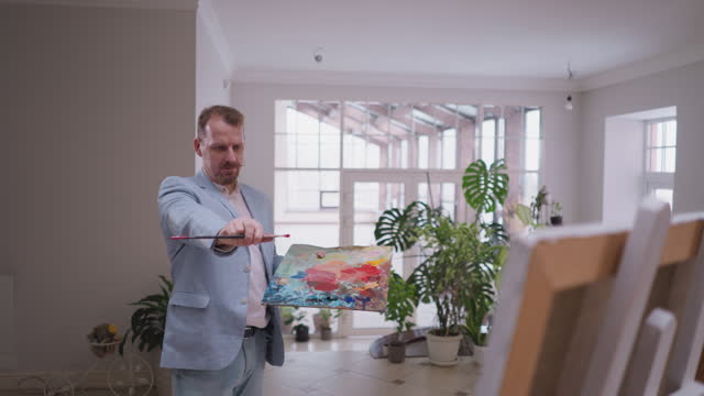 Man painter examines results of art work