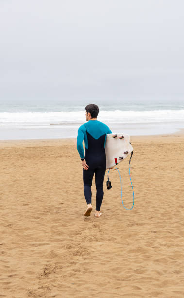 istock Surfer Walking Towards Ocean with Surfboard, copy space. 2043384598